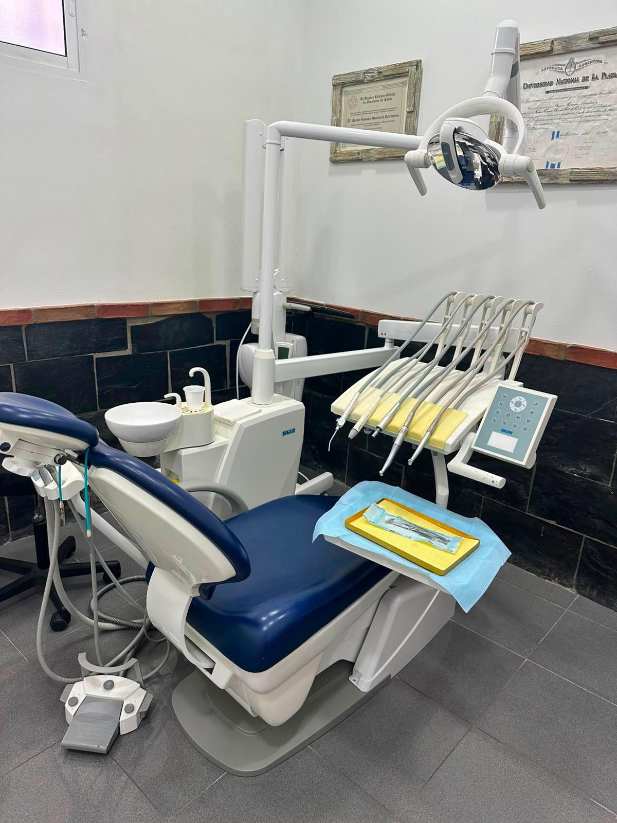 Gabinete dental con sillón azul y equipo Siger